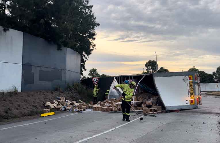 The B-double tipped on its side at the John Oxley Drive and Oxley Highway roundabout. Photos: supplied by @PortMacquarieOnScene.