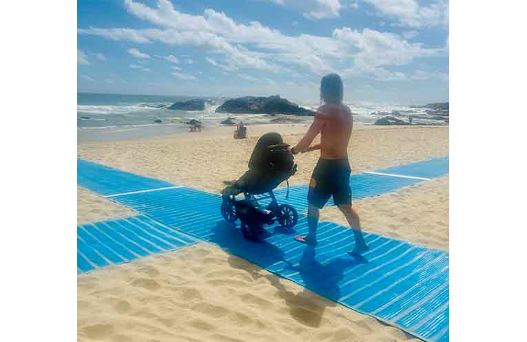 A pram user utilises the matting to access the beach.